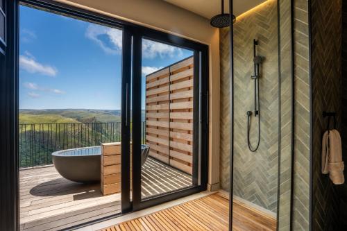 a bathroom with a tub on a deck with a view at Mantis Hiddn in Addo in Addo
