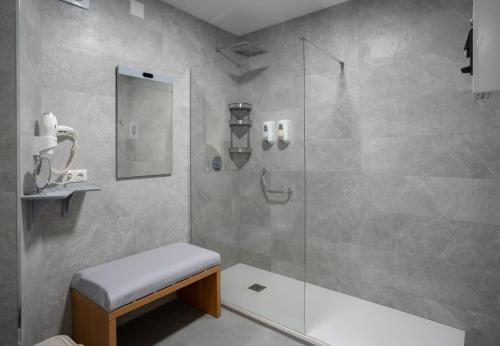 a bathroom with a shower with a bench in it at Palm Beach Club Apartamentos Carihuela in Torremolinos