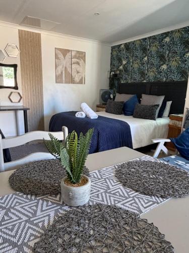 a hotel room with two beds and a potted plant at Evening Star Guest Units in Fichardtpark