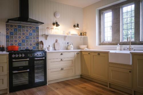 a kitchen with a stove and a sink at Costers Lodge in Midhurst