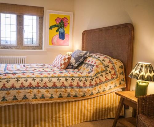 a bedroom with a bed with a quilt on it at Costers Lodge in Midhurst
