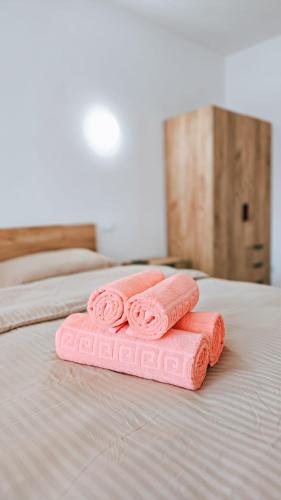 two folded pink towels sitting on a bed at Cosy apart 3 Fagaras in Făgăraş