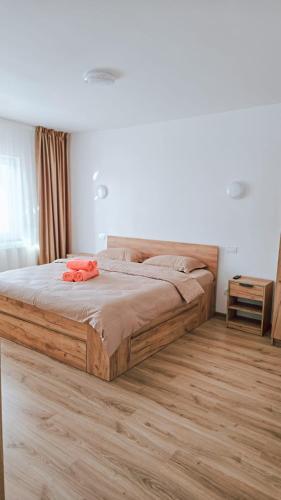 a bed in a bedroom with a wooden floor at Cosy apart 3 Fagaras in Făgăraş