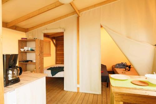 a small room with a kitchen and a bedroom at Camping Le Pavillon bleu in L'Aiguillon-la-Presqu'île
