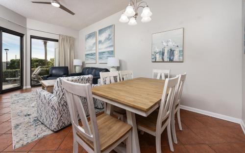 a dining room and living room with a wooden table and chairs at Phoenix VI 6004 in Orange Beach