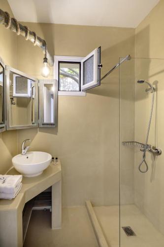 a bathroom with a sink and a glass shower at Kefalonian Oneira Villas in Mousata