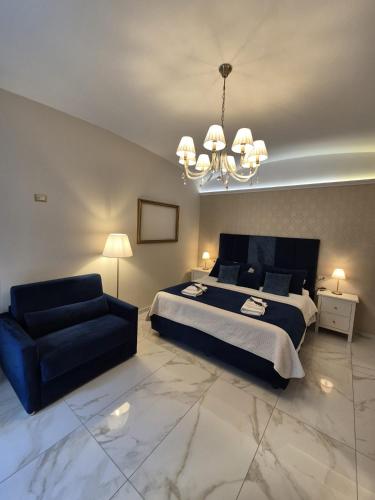 a bedroom with a bed and a couch and a chandelier at Napoli Sogno Infinito in Naples