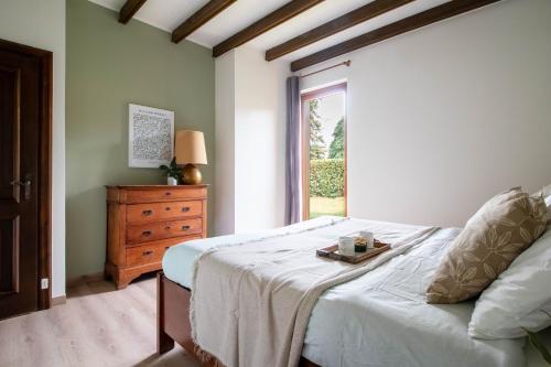 a bedroom with a bed with a dresser and a window at Parco Hermitage - Vila Camelia in Porto Valtravaglia