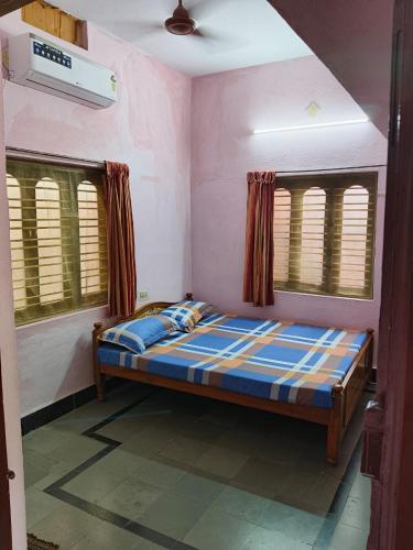 a bedroom with a bed in a room with windows at Garden Villa, Hyderabad in Hyderabad