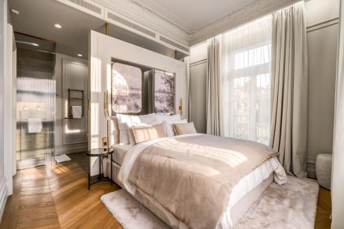 a bedroom with a large bed and a large window at Hotel Petit Bois - Adults from 14 in Balatonfüred