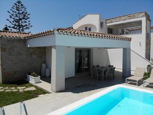 a villa with a swimming pool and a house at Villetta Maluva - Budoni in Budoni