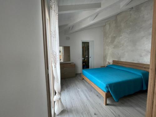a bedroom with a blue bed and a mirror at Villetta Maluva - Budoni in Budoni