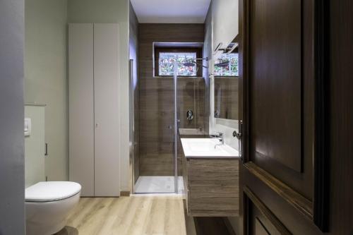a bathroom with a toilet and a sink and a shower at Parco Hermitage - Vila Camelia in Porto Valtravaglia