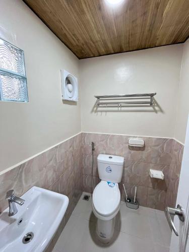 a bathroom with a toilet and a sink at Natalie's Homestay Bed and Breakfast in El Nido