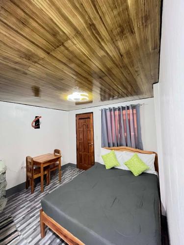 a bedroom with a bed and a wooden ceiling at Natalie's Homestay Bed and Breakfast in El Nido