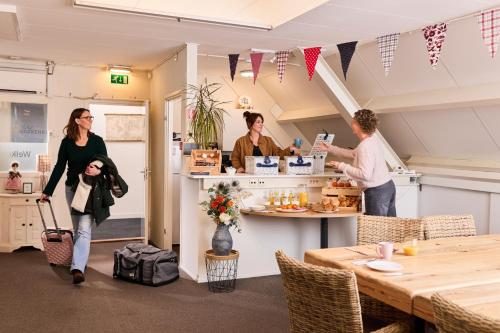 a group of people standing at a counter in a restaurant at B&B Hartje Spakenburg in Spakenburg