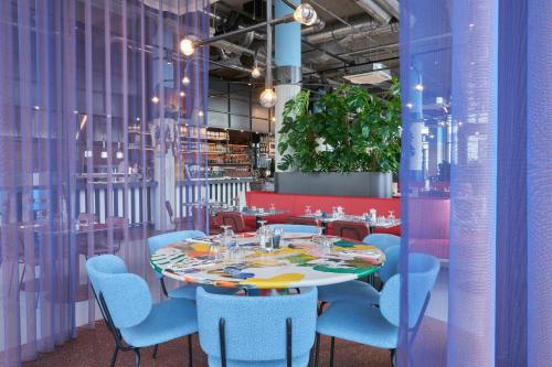 a dining room with a table and blue chairs at The Social Hub Delft in Delft