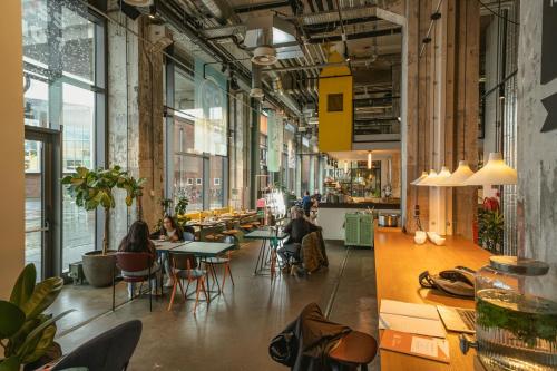 a room with people sitting at tables in a building at The Social Hub Maastricht in Maastricht