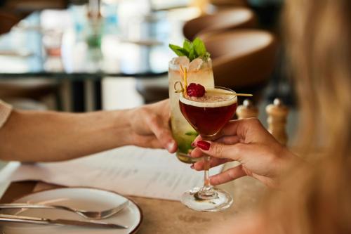 a woman holding a drink in a glass at The Social Hub Maastricht in Maastricht