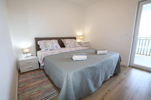 a bedroom with a bed with two towels on it at Apolo Apartments - Pool & Garden Retreat in Pula