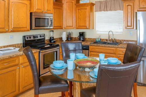 a kitchen with a table and chairs and a kitchen with wooden cabinets at Pompano Beachview Home home in South Padre Island