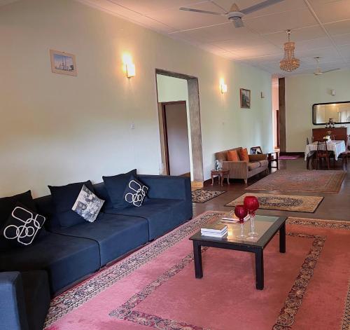 a living room with a blue couch and a table at The Deane Residence Double Room in Colombo