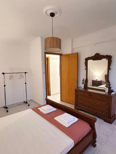 a bedroom with a large bed and a mirror at ElRodia Sea View in Kipséli
