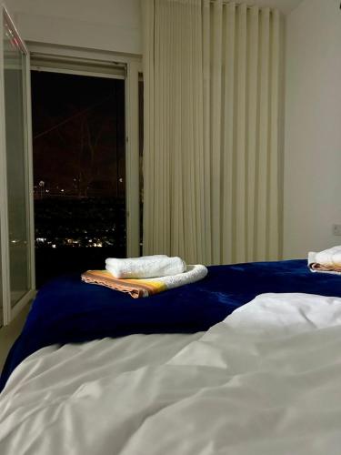 a bed with towels on top of it with a window at Central apartment 3 in Gnjilane