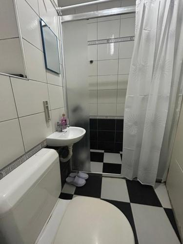 a bathroom with a sink and a toilet and a shower at Central apartment 3 in Gnjilane