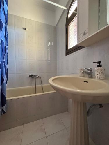 a bathroom with a sink and a bath tub at ElRodia Sea View in Kipséli