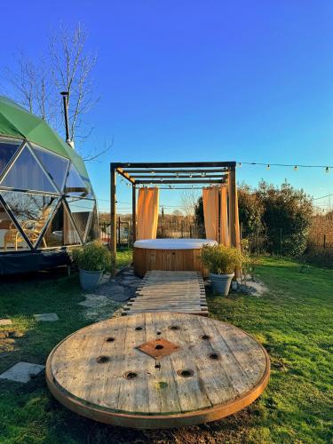 a wooden table in a field with a tent at Dôme Saint-Eloi in Floursies