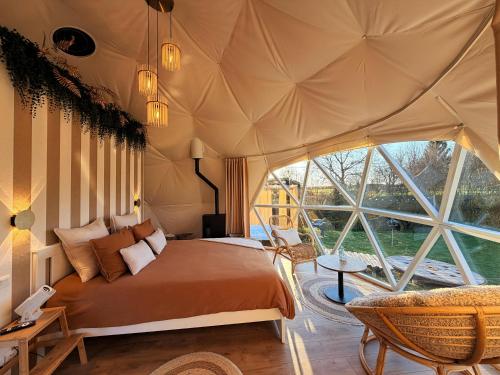 a bedroom with a bed and a large window at Dôme Saint-Eloi in Floursies