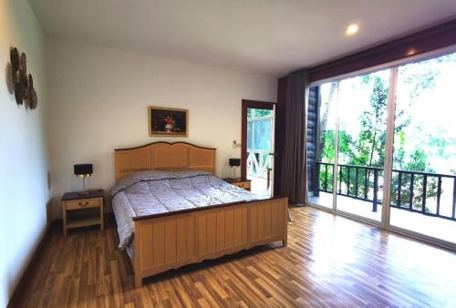 a bedroom with a bed and a large window at Trivista Khaoyai in Ban Khanong Phra Klang (1)