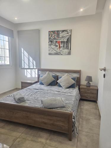 a bedroom with a large bed with blue pillows at 2 bedroom home sea view in Pyla