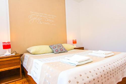 a bedroom with two beds with towels on them at Apartments Miljenko in Dobropoljana
