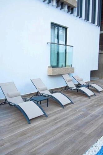 Un grupo de sillas y una mesa en una habitación. en Belrose Place, en Accra