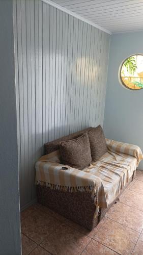 a couch sitting in a corner of a room at Casa simples e arejada in Caxias do Sul