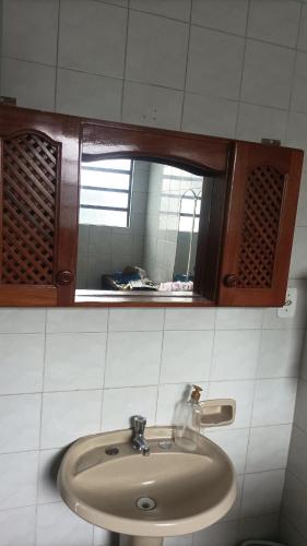 a bathroom with a sink and a mirror at Casa simples e arejada in Caxias do Sul