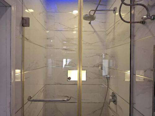 a shower with a glass door in a bathroom at Presken Apartment Ikoyi in Lagos