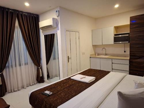 a hotel room with a large bed and a kitchen at Presken Apartment Ikoyi in Lagos