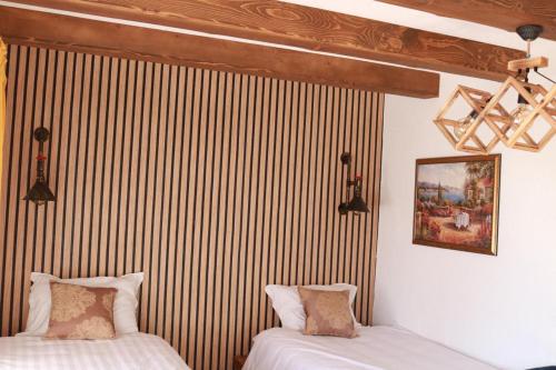 two beds in a room with a striped wall at Apartments Kenan in Plav