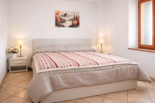 a bed in a bedroom with two lamps on two tables at Jolie Maison in Châtillon