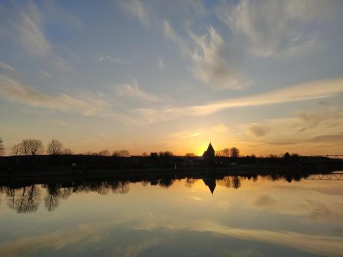 a reflection of a church in the water at sunset at Ferienwohnungen Mamat in Haltern