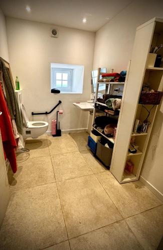 a bathroom with a toilet and a tiled floor at Charming house in an old rectory PMR in Tréguier