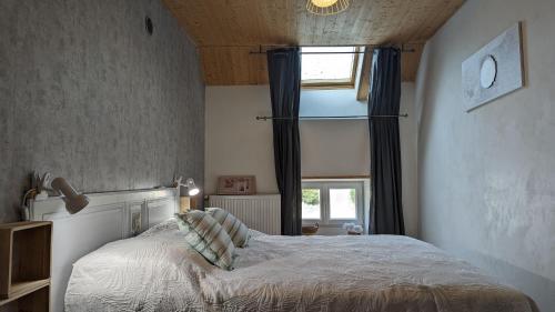 a bedroom with a bed in front of a window at La Belle Noue in Bellenod-sur-Seine