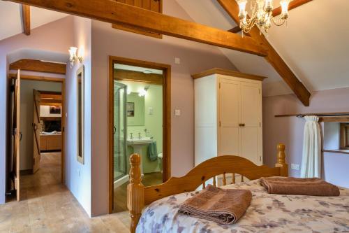 a bedroom with a bed and a bathroom at Finest Retreats - Oak Leaf Cottage in Beaworthy