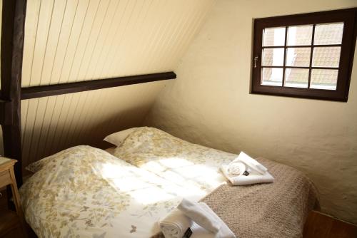 una camera da letto con un letto con asciugamani sopra di Cottage Nostalgia a Damme