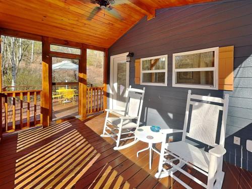 a cabin with two chairs and a table on a deck at Caney Creek in Jenkins Mill
