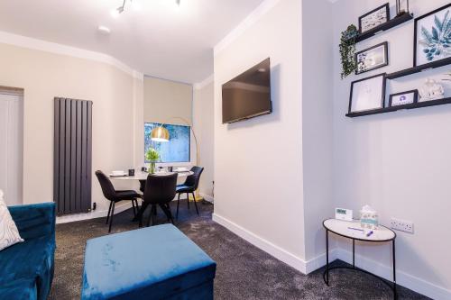 a living room with a blue couch and a table at Westminster Apartments by YourStays in Crewe