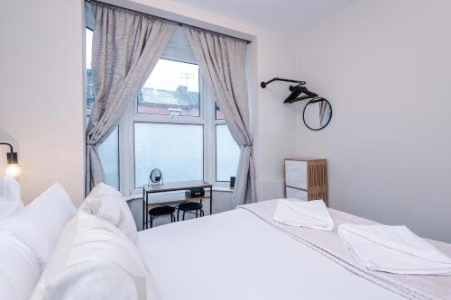a bedroom with two beds and a large window at Westminster Apartments by YourStays in Crewe